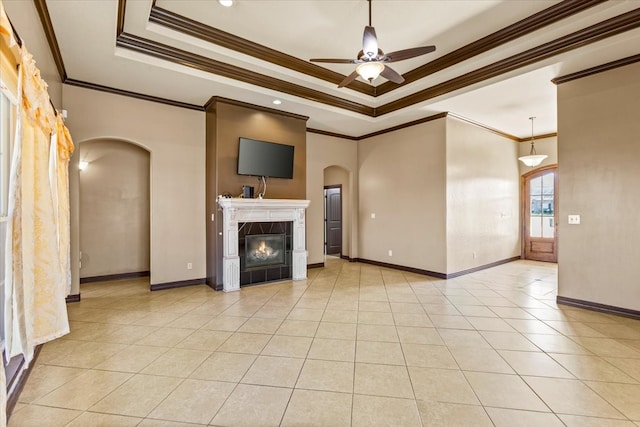 unfurnished living room with ceiling fan, a raised ceiling, and crown molding