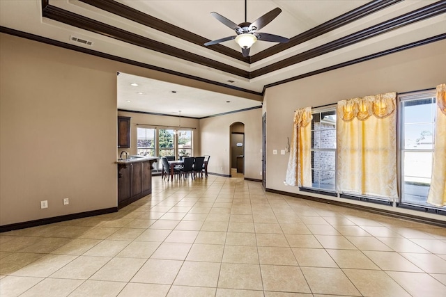 tiled spare room with a tray ceiling, ceiling fan, and ornamental molding