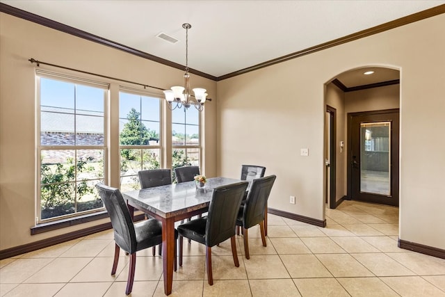 tiled dining area with a chandelier and crown molding