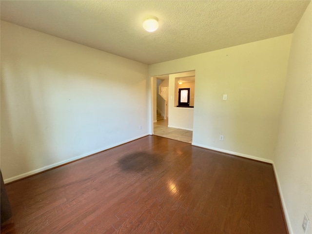 spare room with wood-type flooring and a textured ceiling