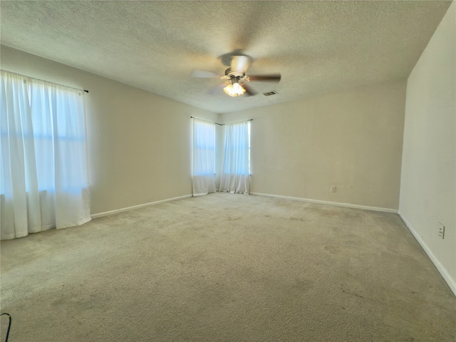 carpeted empty room with ceiling fan and a textured ceiling