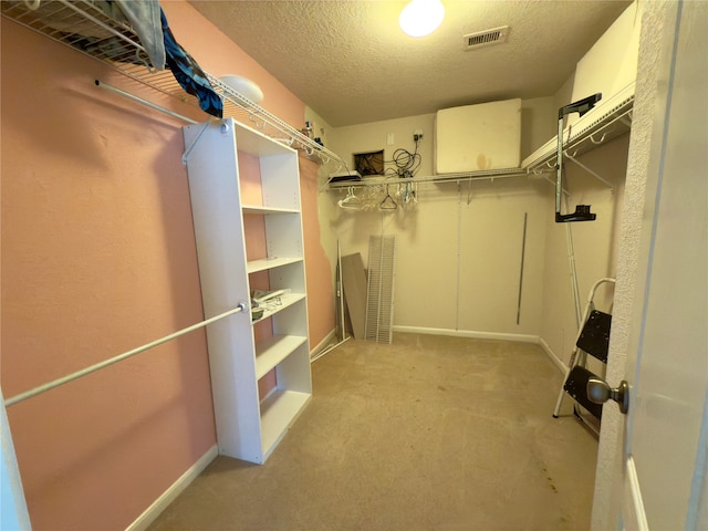 walk in closet featuring light colored carpet