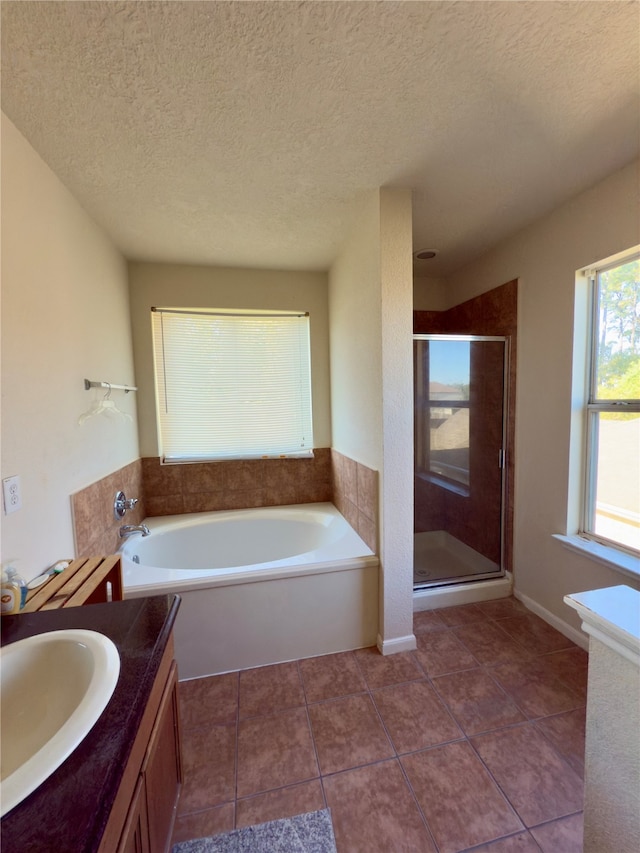 bathroom featuring tile patterned flooring, vanity, a textured ceiling, and independent shower and bath