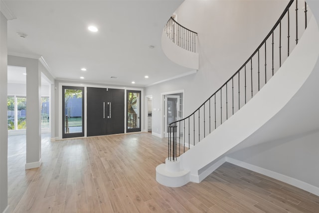 foyer with light hardwood / wood-style floors and ornamental molding