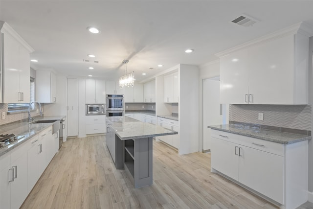 kitchen with white cabinets, appliances with stainless steel finishes, and a center island