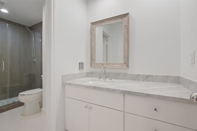 bathroom featuring an enclosed shower, vanity, and toilet