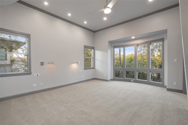 carpeted empty room with ceiling fan and ornamental molding