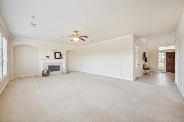 unfurnished living room with a wealth of natural light, crown molding, and ceiling fan