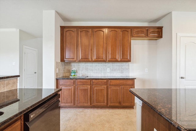 kitchen featuring backsplash, dishwasher, light tile patterned floors, and dark stone counters