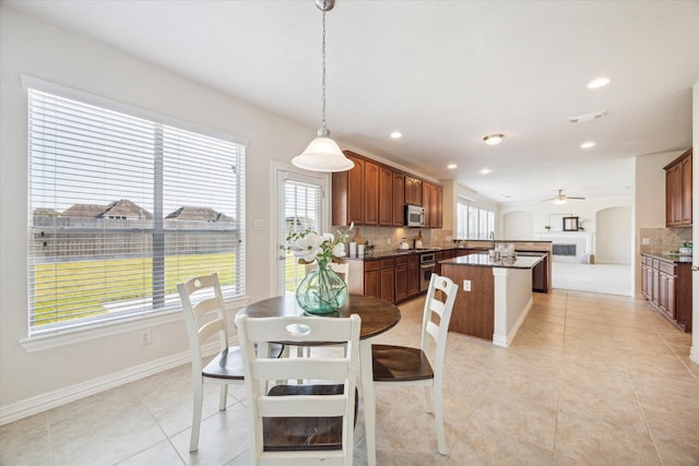 tiled dining area featuring plenty of natural light and ceiling fan