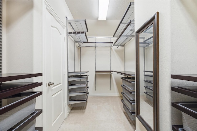 walk in closet with light carpet