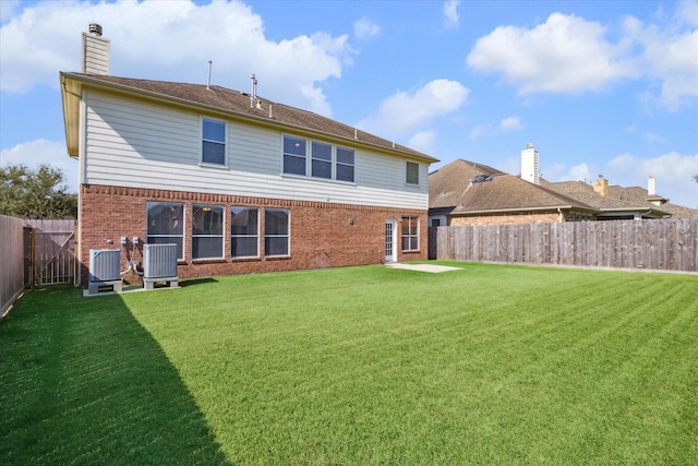 back of property featuring a yard and central AC