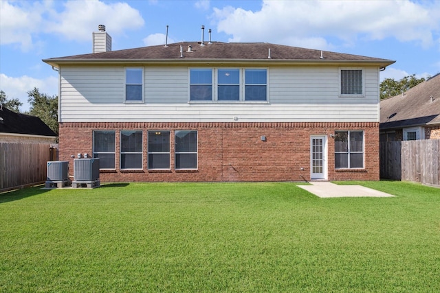 rear view of property featuring a lawn and cooling unit