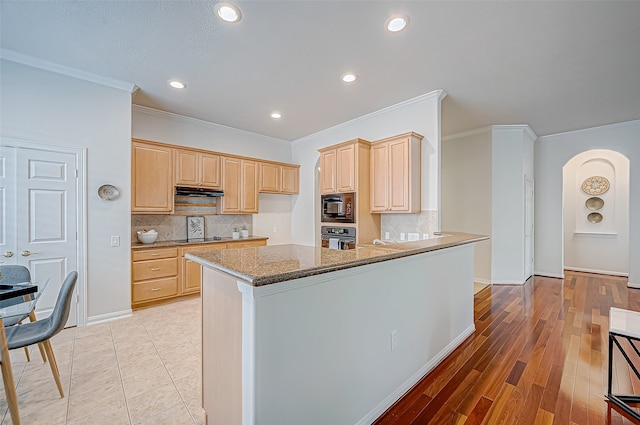 kitchen featuring black appliances, light hardwood / wood-style floors, kitchen peninsula, and light brown cabinetry