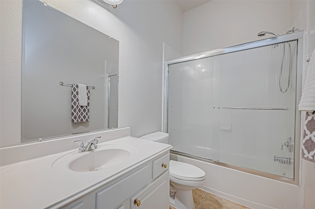 full bathroom with tile patterned flooring, vanity, enclosed tub / shower combo, and toilet