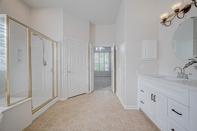 bathroom featuring tile patterned flooring, vanity, ceiling fan with notable chandelier, and a shower with shower door