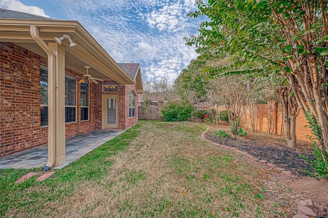 view of yard featuring ceiling fan and a patio