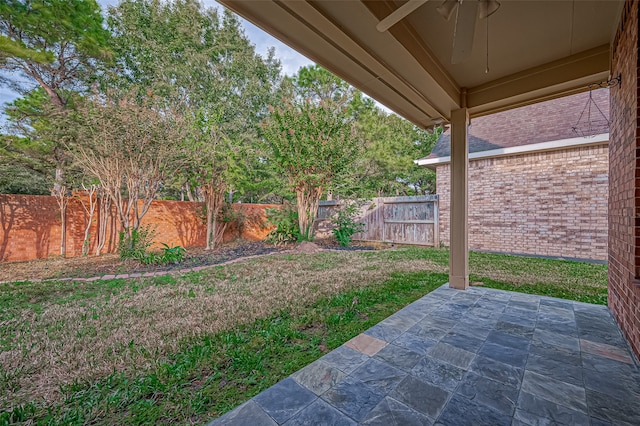 view of yard featuring ceiling fan and a patio