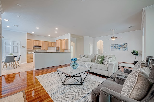 living room featuring ceiling fan, light hardwood / wood-style flooring, and ornamental molding