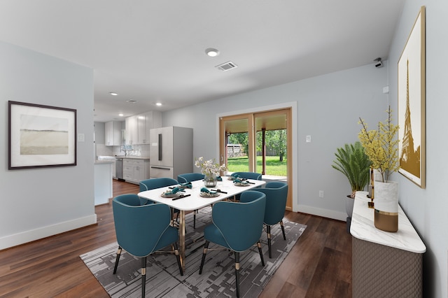 dining space featuring sink and dark wood-type flooring