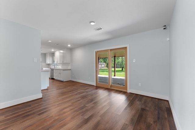 unfurnished living room with dark hardwood / wood-style floors and sink