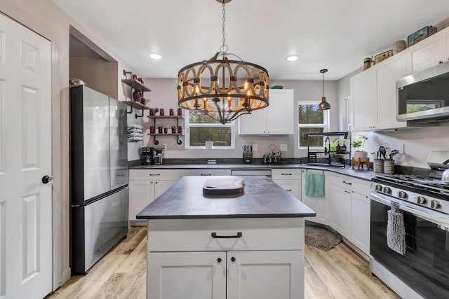 kitchen with a center island, sink, appliances with stainless steel finishes, and light hardwood / wood-style flooring