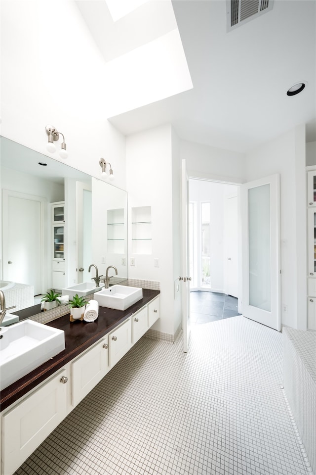 bathroom with built in shelves, vanity, and tile patterned floors