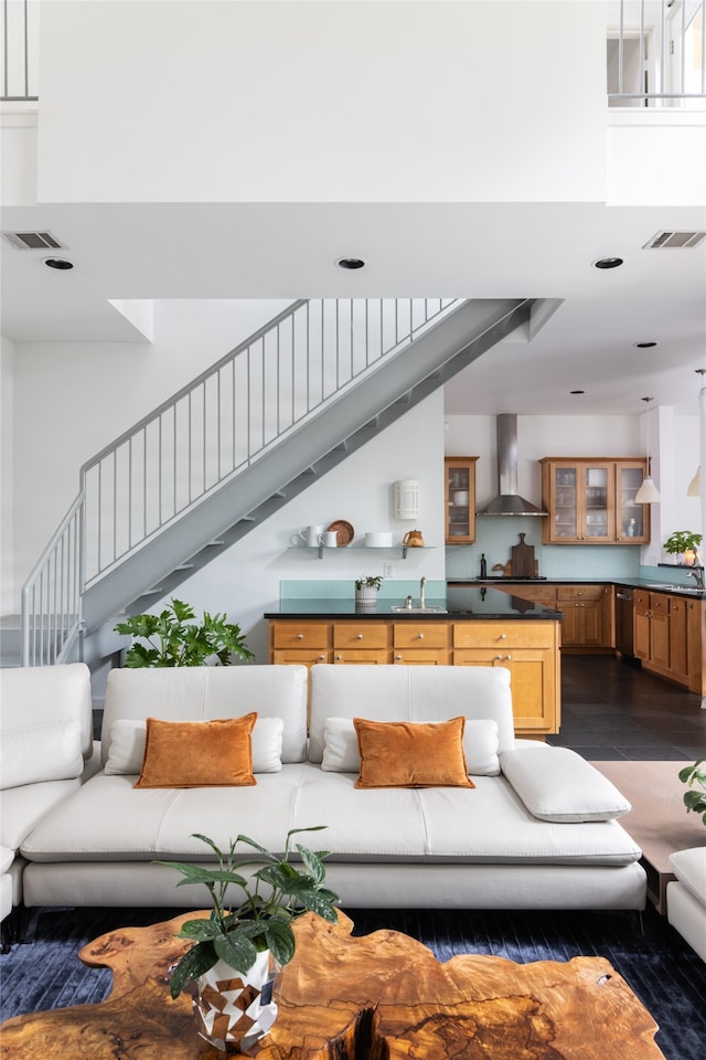 living room featuring a towering ceiling, dark hardwood / wood-style floors, and sink