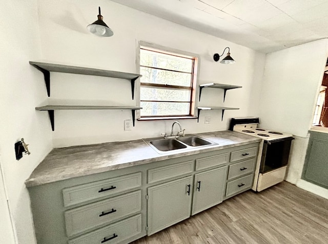 kitchen with white range with electric cooktop, light wood-type flooring, and sink