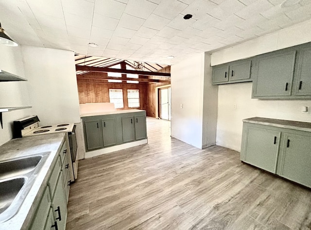 kitchen featuring sink, light hardwood / wood-style floors, wooden walls, white stove, and green cabinetry