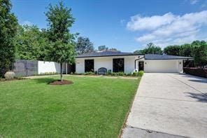 ranch-style house featuring a garage and a front yard