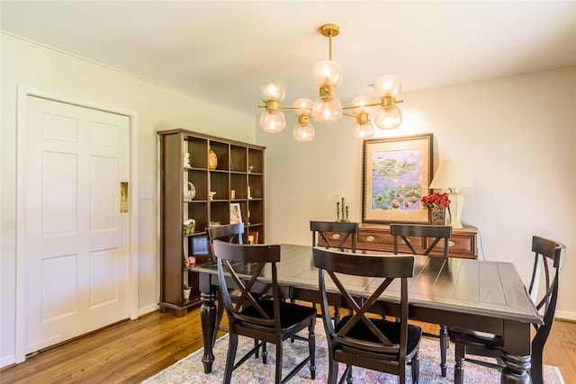 dining space with a chandelier, crown molding, and wood-type flooring