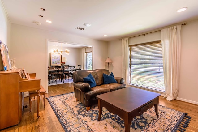 living room featuring hardwood / wood-style flooring, a healthy amount of sunlight, and an inviting chandelier