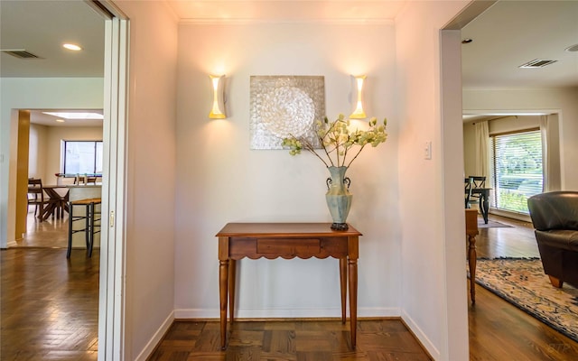 hall featuring dark parquet flooring and crown molding