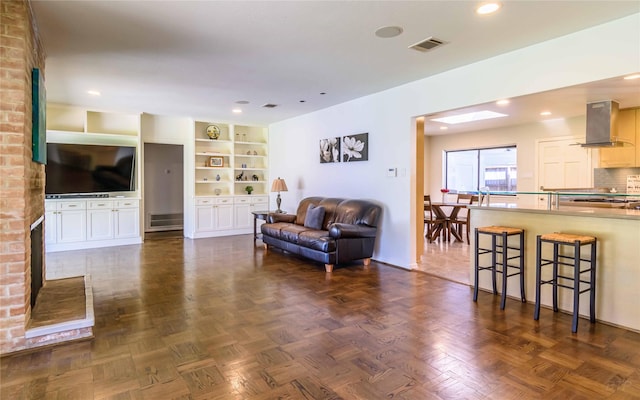 living room with dark parquet flooring and built in features