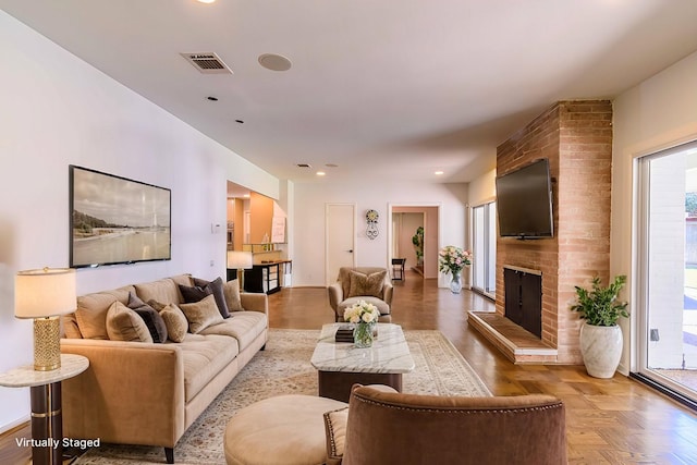 living room with parquet floors and a brick fireplace