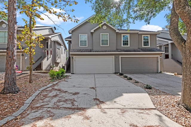 view of front of home with concrete driveway, stairway, and an attached garage