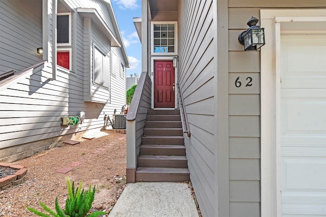 doorway to property with a garage and central AC