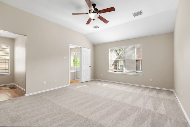 carpeted empty room with ceiling fan and vaulted ceiling