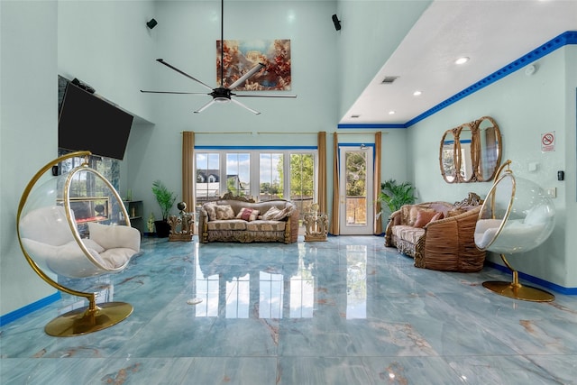 sitting room featuring ceiling fan and a high ceiling