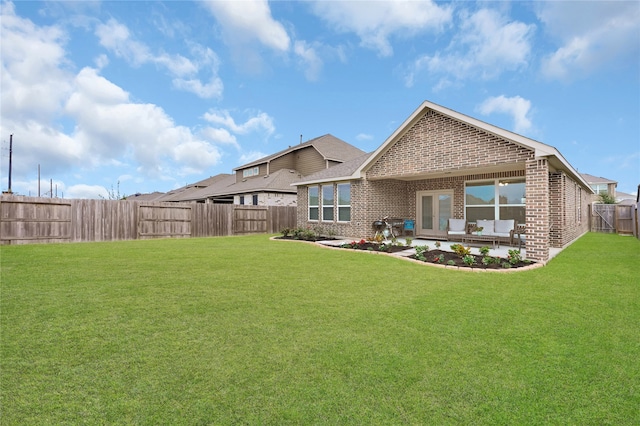 back of house featuring a lawn and a patio