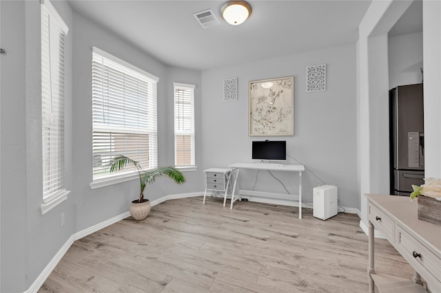 home office with light hardwood / wood-style flooring