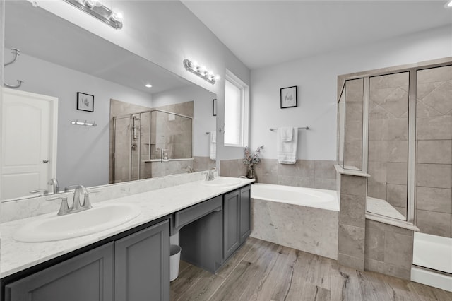 bathroom with hardwood / wood-style floors, vanity, and plus walk in shower