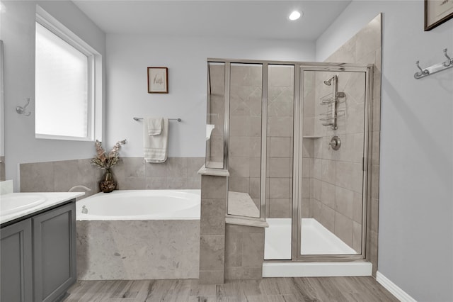 bathroom with separate shower and tub, vanity, and hardwood / wood-style flooring