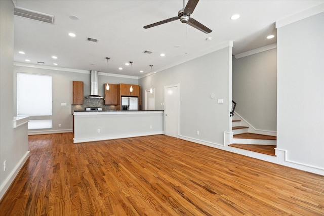 unfurnished living room featuring ornamental molding, ceiling fan, and light wood-type flooring