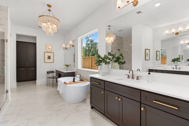 bathroom with a soaking tub, marble finish floor, a notable chandelier, a shower stall, and a sink