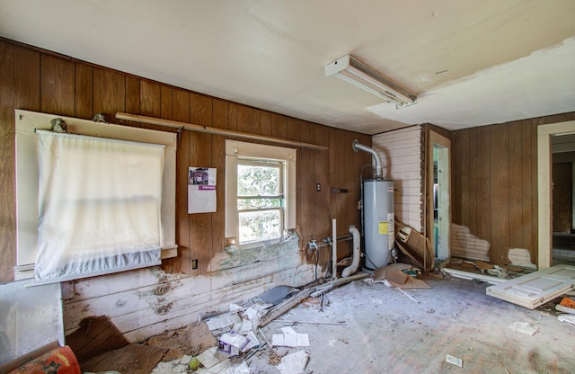 miscellaneous room with wooden walls and water heater