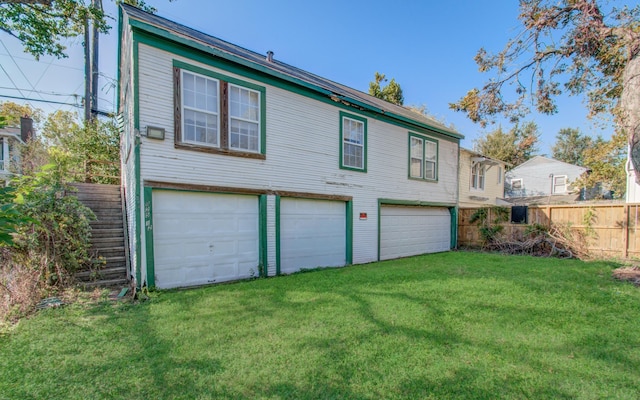 rear view of house with a lawn and a garage