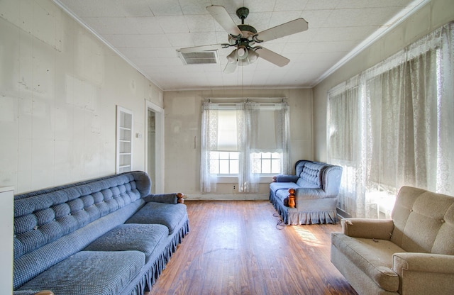 living room with built in shelves, ceiling fan, ornamental molding, and hardwood / wood-style flooring