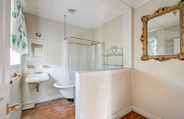 bathroom with hardwood / wood-style floors, shower / tub combo, and sink